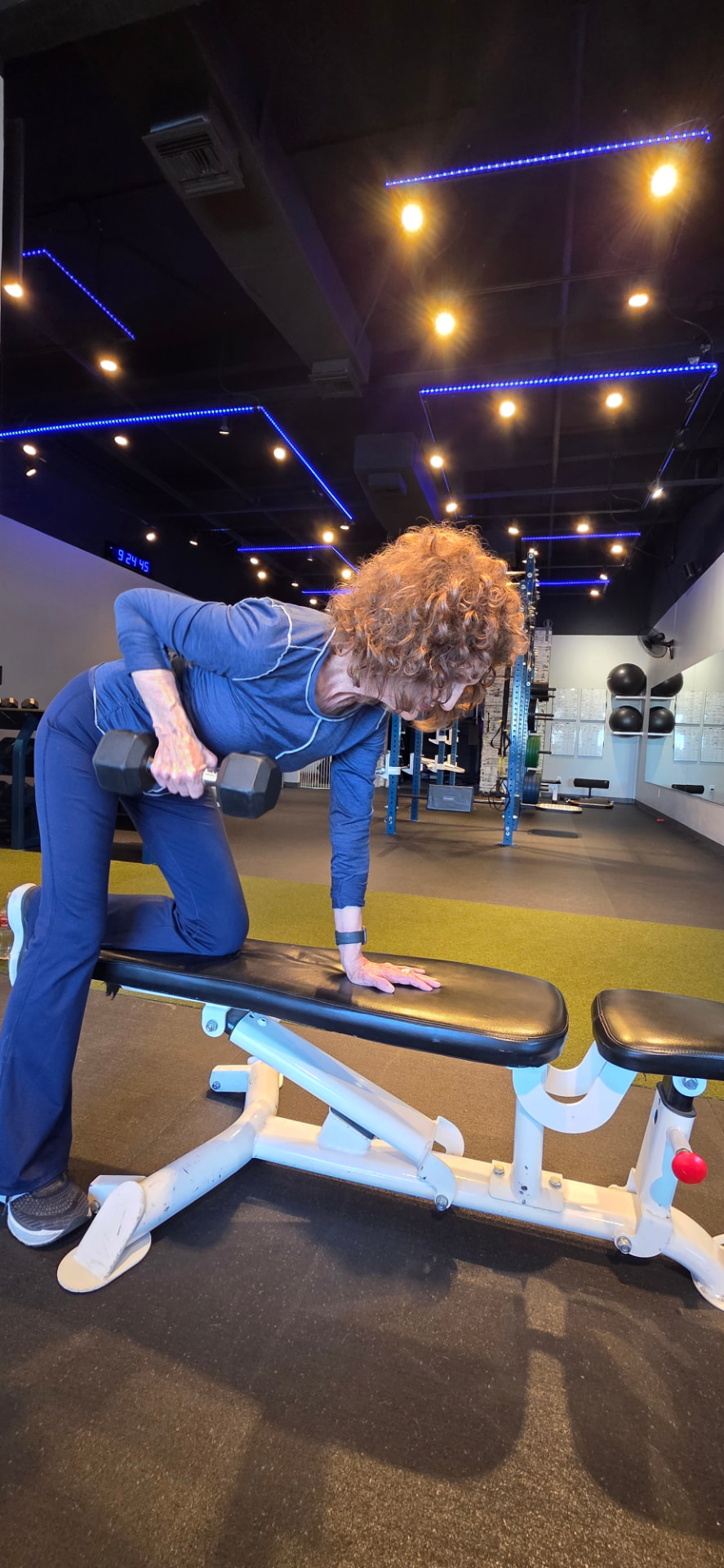 Active adult performing single-arm dumbbell rows on a bench at Everybitfit