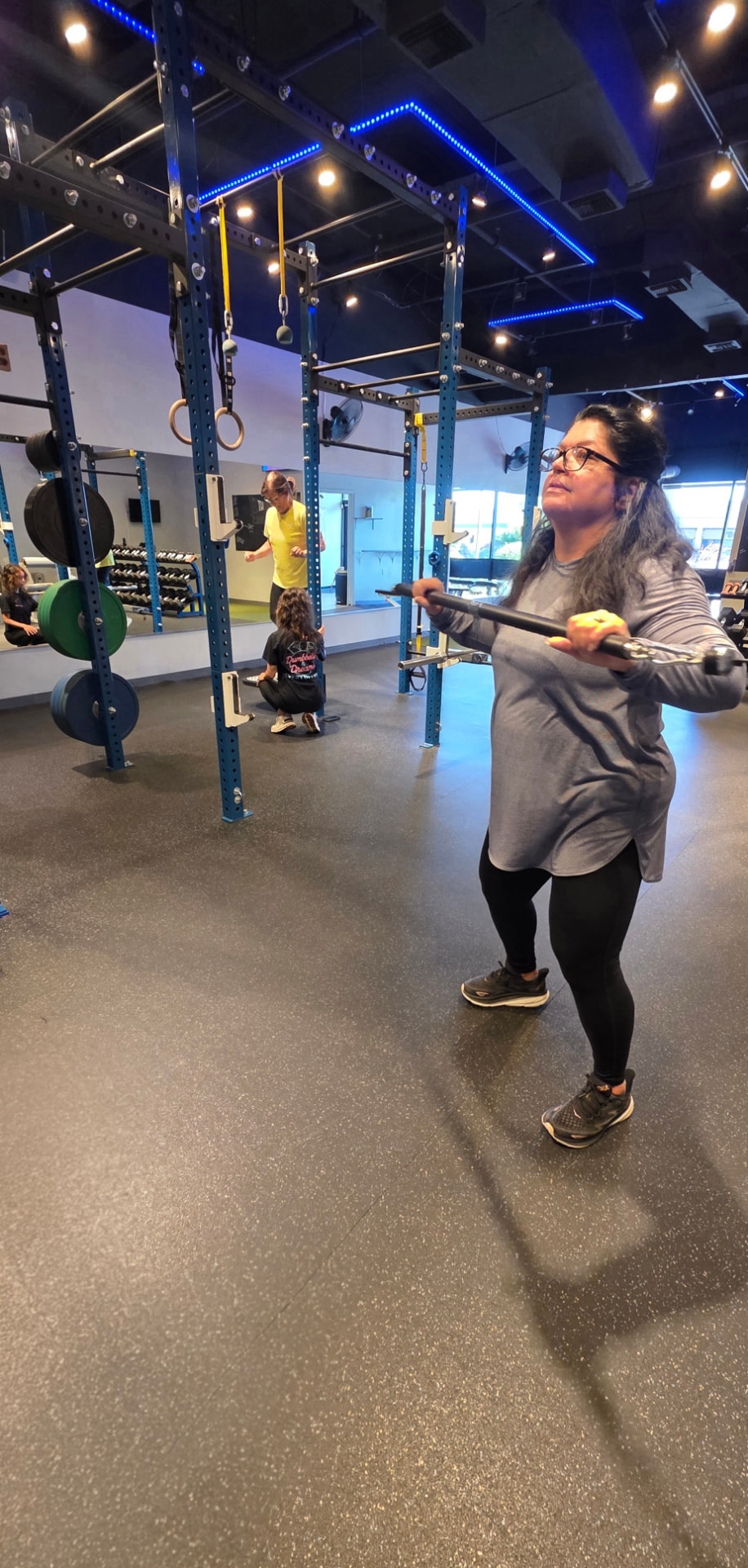Woman training core and balance with a cable bar at Everybitfit